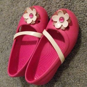 Pink Crocs flats with flower